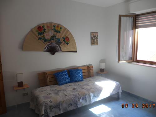 a bedroom with a bed with blue pillows on it at Villetta Mare Ventotene in Ventotene