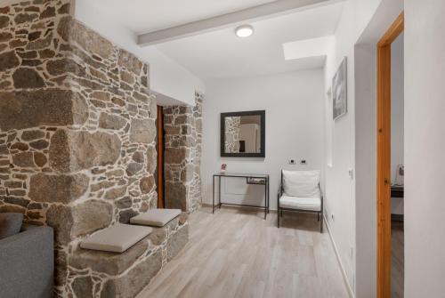 a living room with a stone wall and a chair at El Blanquizal B in San Nicolás