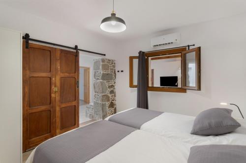 a bedroom with two beds and a wooden door at El Blanquizal B in San Nicolás