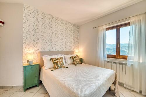 a bedroom with a bed with two pillows and a window at Umbria Casavacanze Vista Panoramica in Montefranco