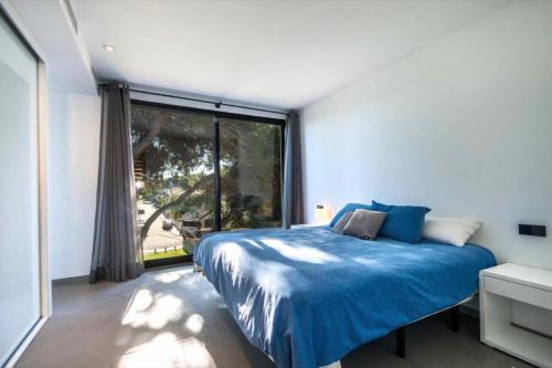 a bedroom with a blue bed and a large window at Naturamar in Muro