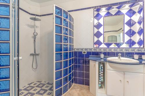 a blue tiled bathroom with a sink and a shower at Crisol Apartamento in Puerto de la Madera