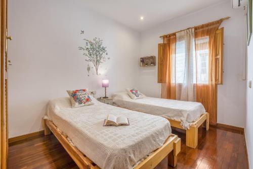 a room with two beds with books on them at Casa El Naranjo Azul Granada in Lecrin
