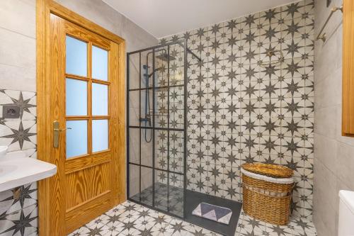 a bathroom with a shower with a glass door at Casa El Naranjo Azul Granada in Lecrin