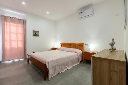 a bedroom with a bed and a dresser and a bed sidx sidx sidx sidx at Emmeci House in Alghero