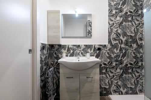 a bathroom with a sink and a mirror at Emmeci House in Alghero