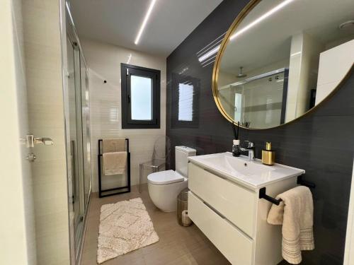 a bathroom with a sink and a mirror and a toilet at Barcelona 11 in Finestrat