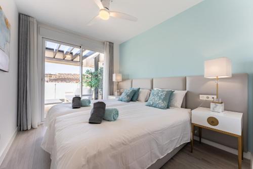 two beds in a bedroom with a large window at 250 La Cala Calaserena in La Cala de Mijas
