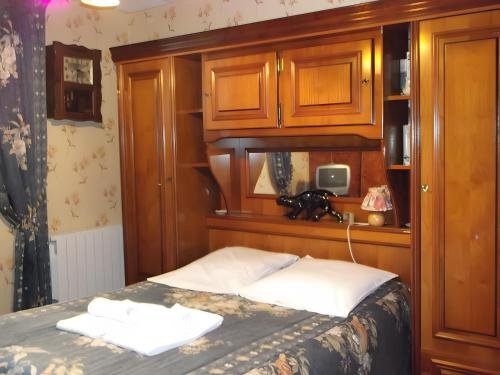 a bedroom with a bed with a wooden headboard at Villa Eugénie in La Bourboule