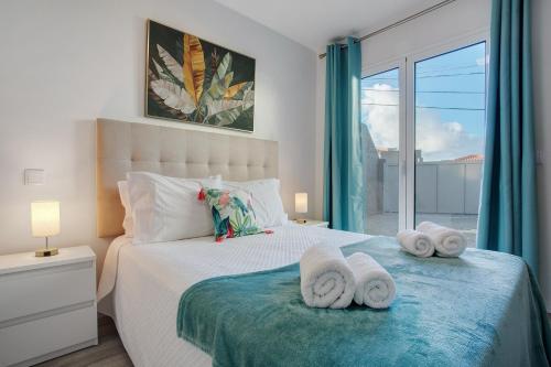 a bedroom with a bed with towels on it at Casa Do Tempo com Jacuzzi in Ribeira Brava