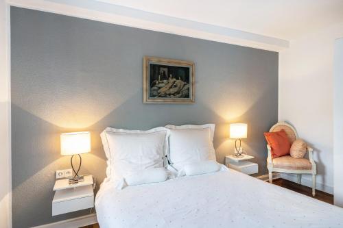 a bedroom with a white bed and two lamps at Ferienwohnung Aachen Süd in Aachen