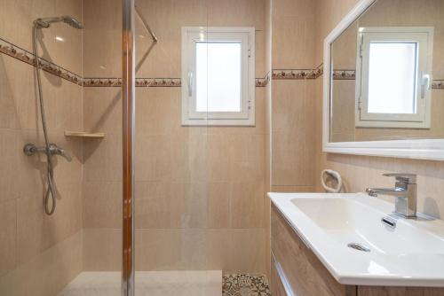 a bathroom with a shower and a sink and a mirror at Casa Cinta in Deltebre