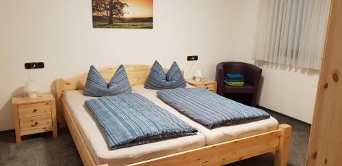 a bedroom with a wooden bed with blue pillows at Fewo Schwarz in Ettenheim