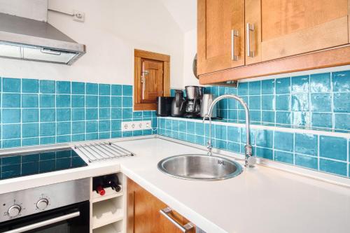 a kitchen with a sink and blue tiles at Casa amarilla del mar piso 3y4 in Villajoyosa