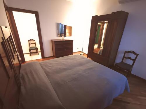 a bedroom with a bed and a dresser and a mirror at Spacious Historic Apartment F1 in Gravedona