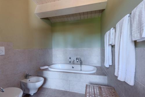 a bathroom with a tub and a toilet and a sink at Villa Salvia in Trequanda