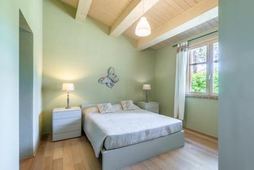 a bedroom with a bed and a butterfly butterfly mirror at Villa Salvia in Trequanda