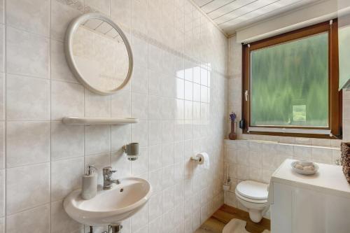 a white bathroom with a sink and a mirror at Wohung zum Ausblick in Plettenberg