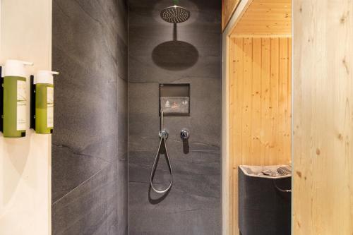 a shower in a bathroom with a black wall at Alpenchalet 19 in Krün
