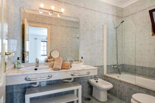 a bathroom with a sink and a toilet and a mirror at Villa Princesa Faina in Tías