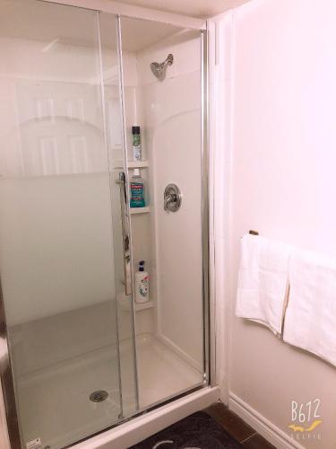 a shower with a glass door in a bathroom at Cozy 2bedroom Basement unit in Toronto