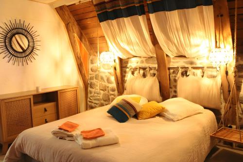 a bedroom with a bed with towels on it at Gite La Grange De Loey in Méallet