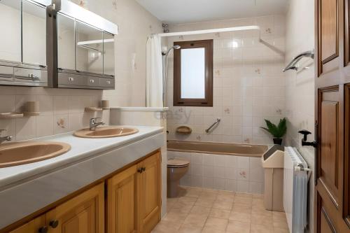 a bathroom with two sinks and a tub and a toilet at Casa Terra de Chispa by Easy Brava in Calonge