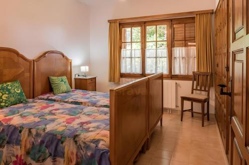 a bedroom with a bed and a chair and a window at Casa Terra de Chispa by Easy Brava in Calonge