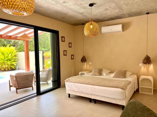 a bedroom with a bed and a sliding glass door at CASA M Peaceful haven with pool in Îlet à Christophe