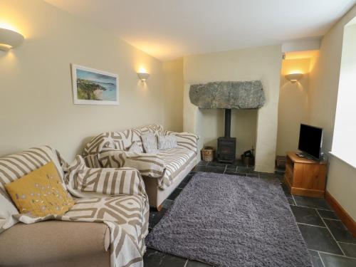a living room with two couches and a fireplace at Chapel House in Llantrisant