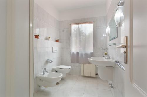 a white bathroom with a toilet and a sink at Hiding Place Apartamento Mocan in Los Realejos