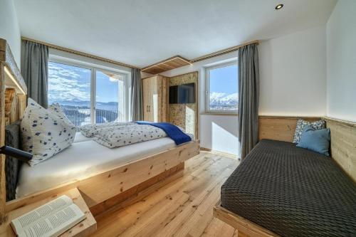 a bedroom with a bed and a large window at Hinterrainer Nature Apartments- New in Avelengo