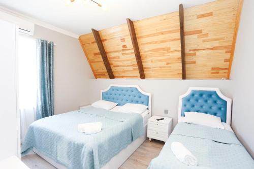 two beds in a bedroom with blue and white at Forest Luxe A-Frame Villa in Quba
