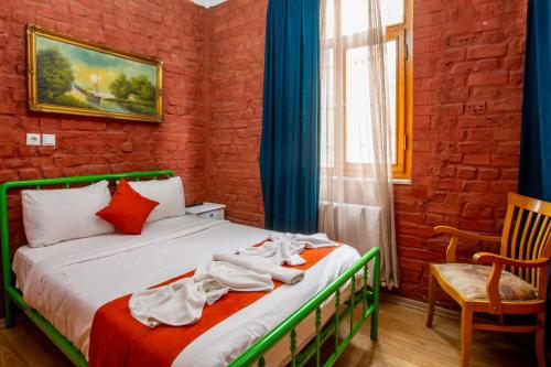 a bedroom with a bed and a chair and a window at 1826 Heritage House in Taksim