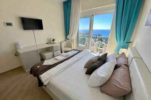 a bedroom with a large bed with a large window at EDEM free parking, sea view & pool in Kunje