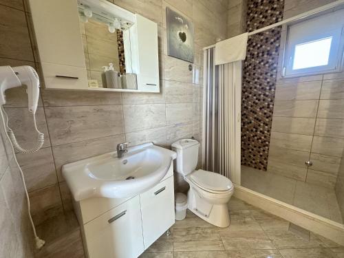 a bathroom with a white sink and a toilet at EDEM free parking, sea view & pool in Kunje