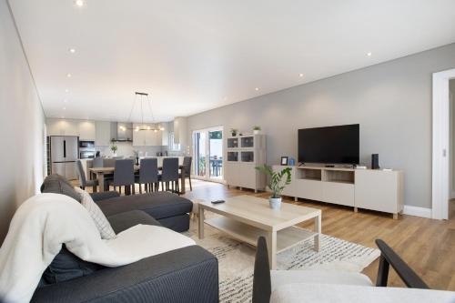 a living room with a couch and a dining room at Casa D'Avó - Family Coastal Escape in Casa Nova