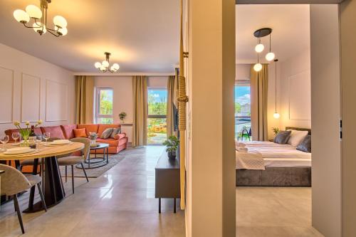 a living room with a bed and a dining room at Amber Seaside Apartment - Luxury Apartment with Balcony and Parking in Gdansk in Gdańsk