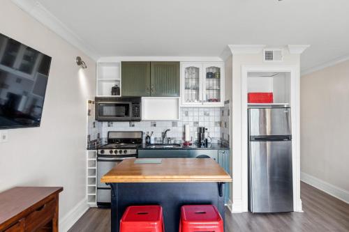 a kitchen with green and white appliances and red stools at CB Boardwalk Condo Oceanfront Pool Villa in Carolina Beach
