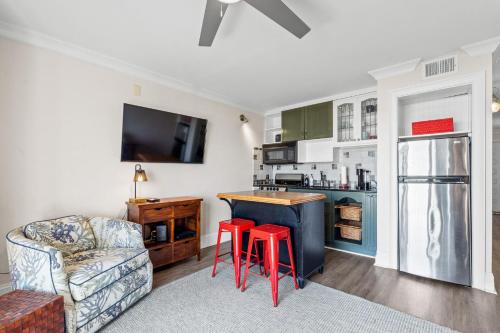 a kitchen with a counter and two red stools at CB Boardwalk Condo Oceanfront Pool Villa in Carolina Beach