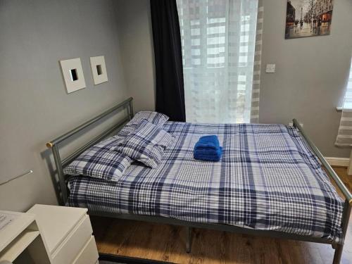 a bed with a blue pillow on it in a room at Cosy Rooms next to St Pancras Station in London
