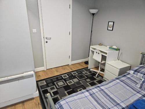 a bedroom with a bed and a desk and a table at Cosy Rooms next to St Pancras Station in London