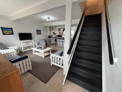 a living room with a staircase and a living room at LaMer No 5 in Stilbaai