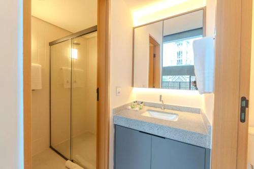a bathroom with a sink and a glass shower at Heritage X in São Paulo