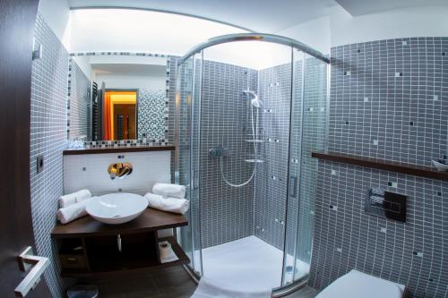a bathroom with a sink and a shower with a sink at Hotel Slunný Dvůr in Jeseník