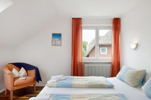 a bedroom with two beds and a chair and a window at Ferienhaus Völkle in Hinterzarten