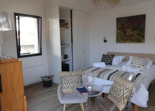 a bedroom with a bed and a table and chairs at Chambres D'hôtes - Noirmoutier in LʼÉpine