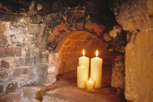 two candles are sitting in a stone archway at Tudor Cottage B&B Frampton in Dorchester