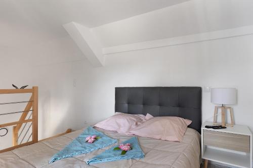 a bedroom with a bed with two flowers on it at Petit gîte bleu jusqu'à 4 personnes in Huillé