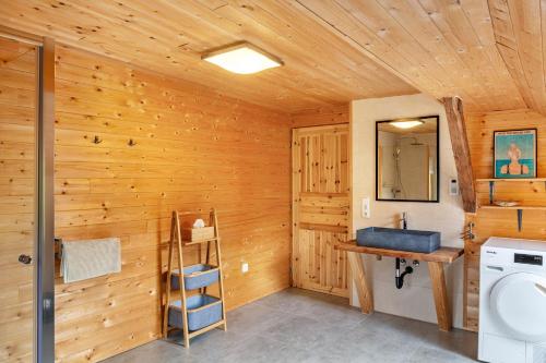 a bathroom with wooden walls and a toilet and a sink at Penthouse im Bauernhaus in Kötschach